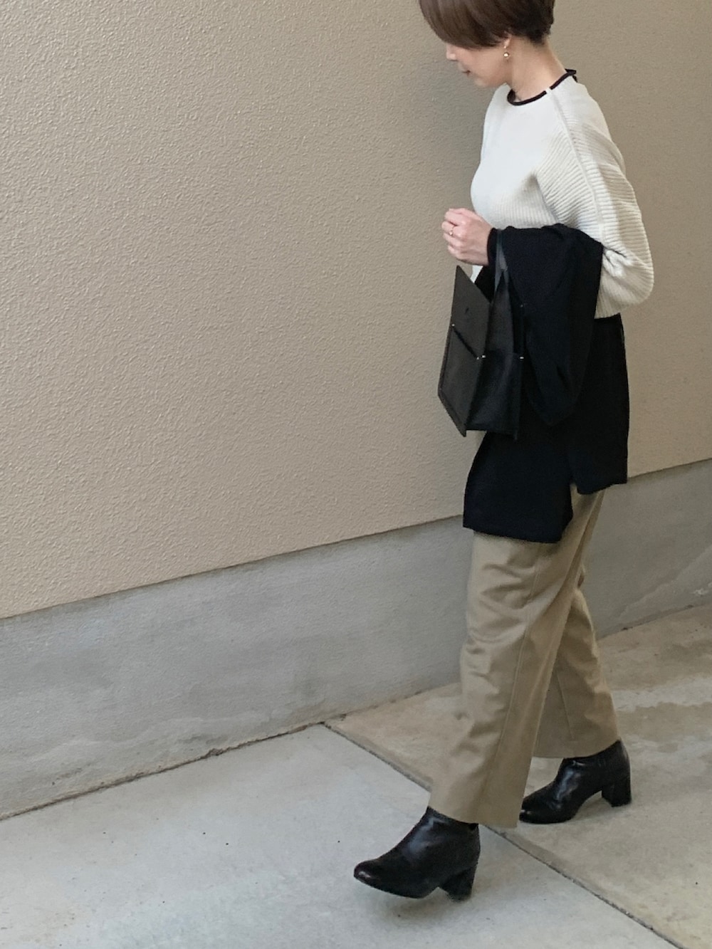 ホワイト系のニット/セーター、ブラック系のテーラードジャケット、ベージュ系のスラックスを着用したレディースの春コーディネートの2枚目の写真