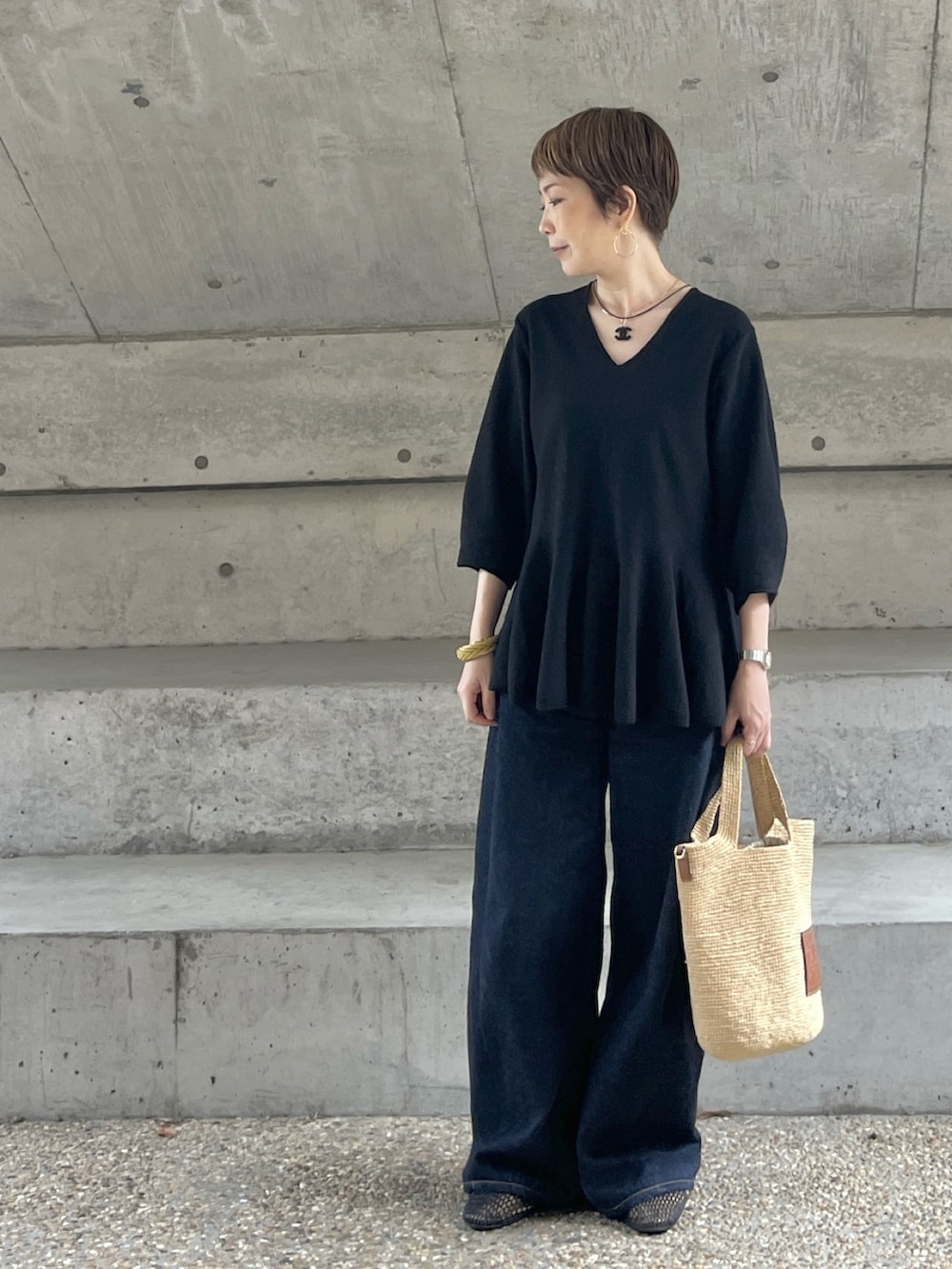 ブラック系のバレエシューズ、ブルー系のデニムパンツ、ブラック系のニット/セーターを着用したレディースの夏コーディネートの4枚目の写真