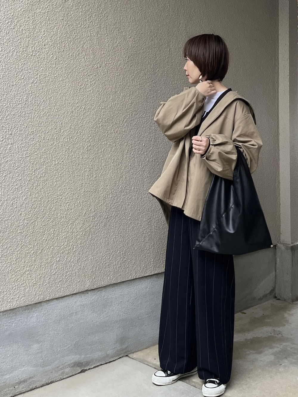 ベージュ系のブルゾン、ブルー系のその他パンツ、ホワイト系のTシャツ/カットソーを着用したレディースの春コーディネートの4枚目の写真