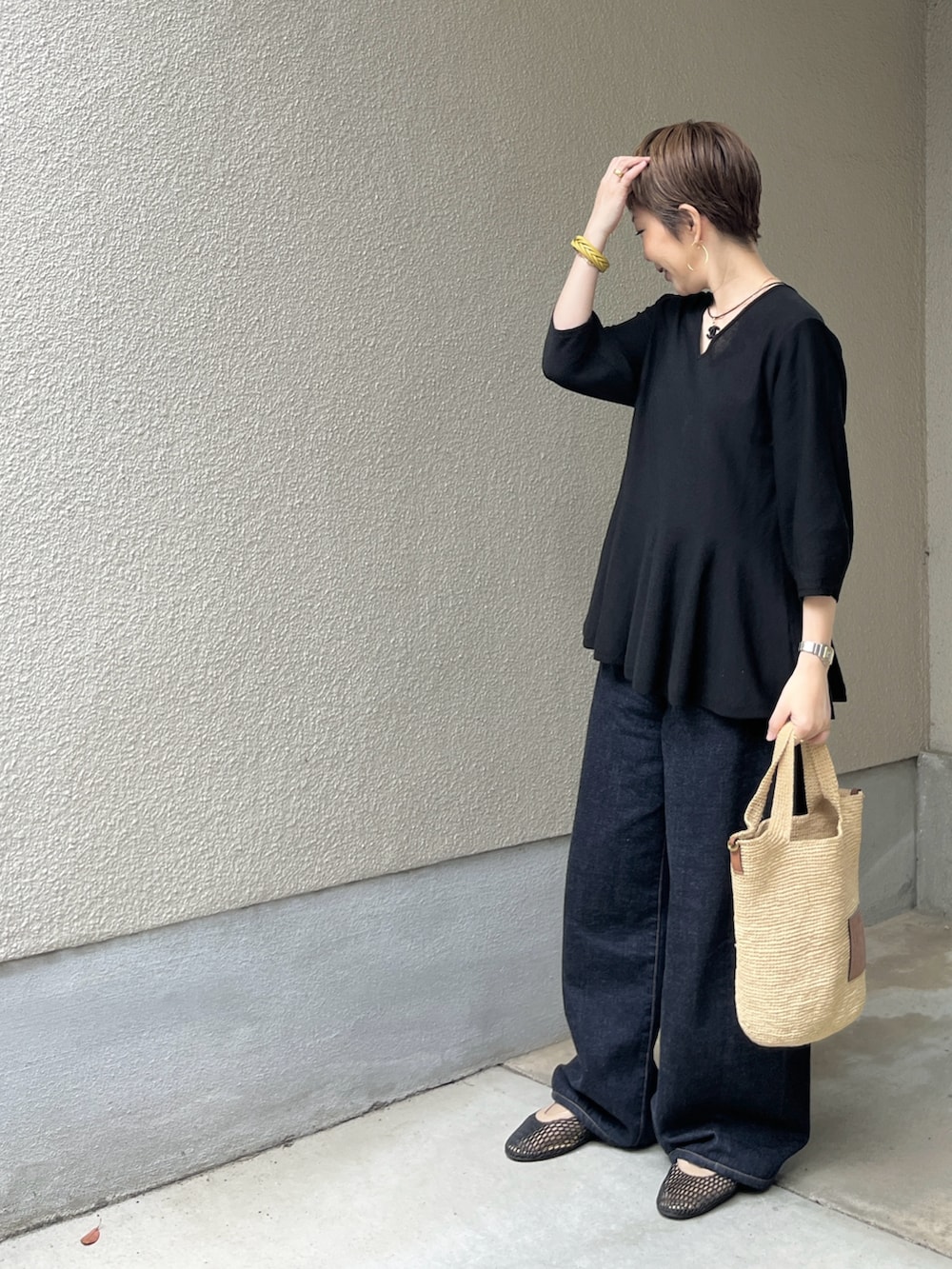 ブラック系のバレエシューズ、ブルー系のデニムパンツ、ブラック系のニット/セーターを着用したレディースの夏コーディネートの2枚目の写真