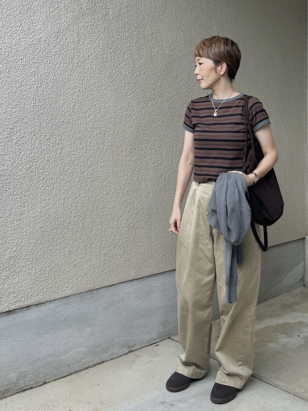 ブラウン系のTシャツ/カットソー、ベージュ系のチノパンツ、ブラウン系のローファーを着用したレディースの秋コーディネートの4枚目の写真