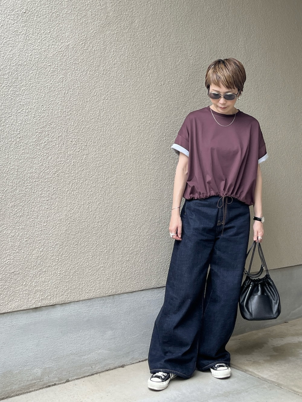 レッド系のTシャツ/カットソー、ブルー系のデニムパンツ、グレー系のサングラスを着用したレディースの春コーディネートの2枚目の写真