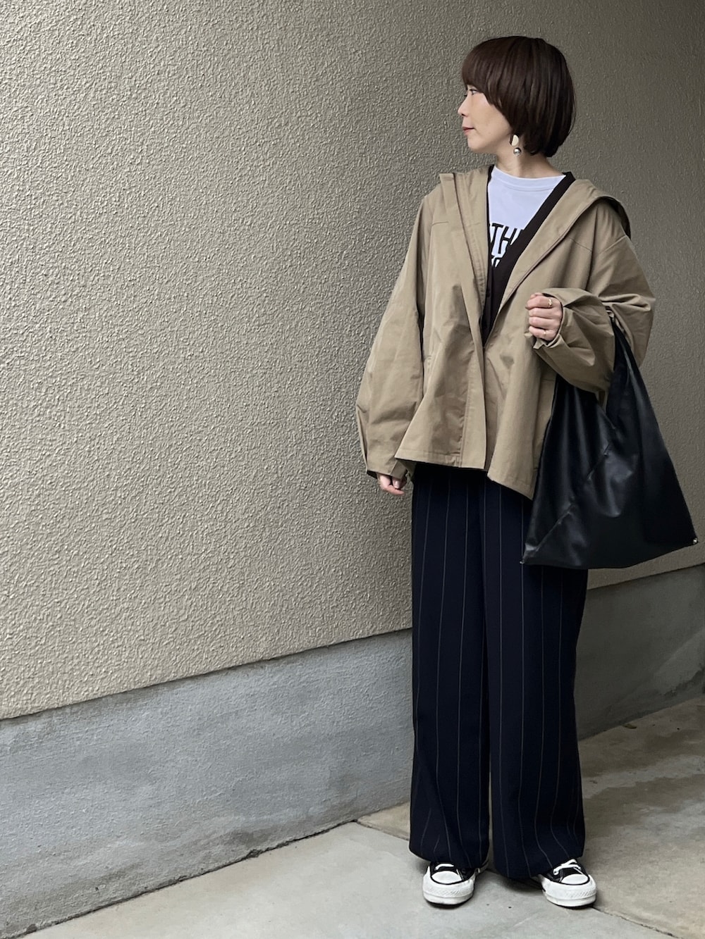 ベージュ系のブルゾン、ブルー系のその他パンツ、ホワイト系のTシャツ/カットソーを着用したレディースの春コーディネートの3枚目の写真