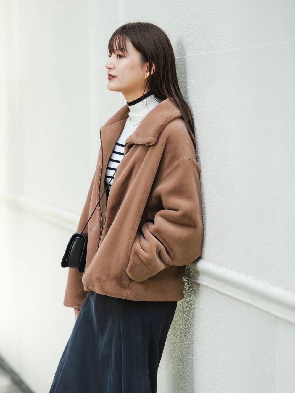 ホワイト系のニット/セーター、イエロー系のその他アウター、グレー系のスカートを着用したレディースの秋コーディネートの3枚目の写真