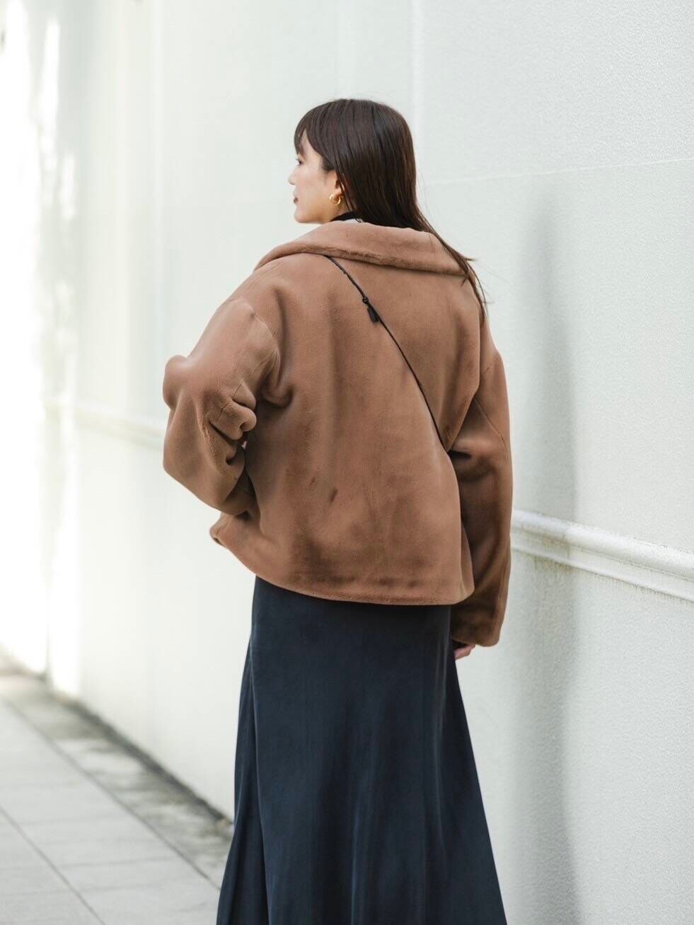 ホワイト系のニット/セーター、イエロー系のその他アウター、グレー系のスカートを着用したレディースの秋コーディネートの4枚目の写真