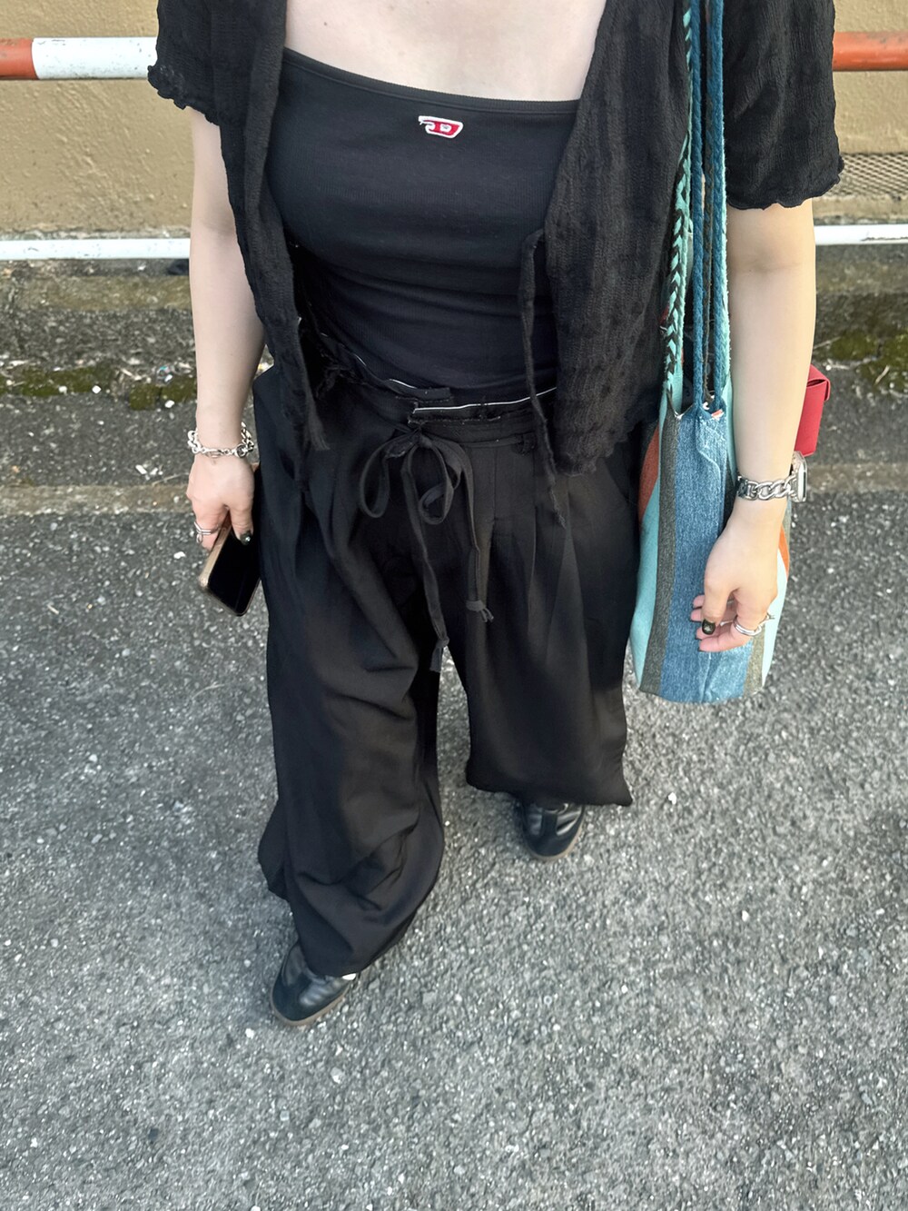 ブルー系のトートバッグ、ブラック系のパンツ、ブラック系のキャミソールを着用したレディースの夏コーディネートの2枚目の写真