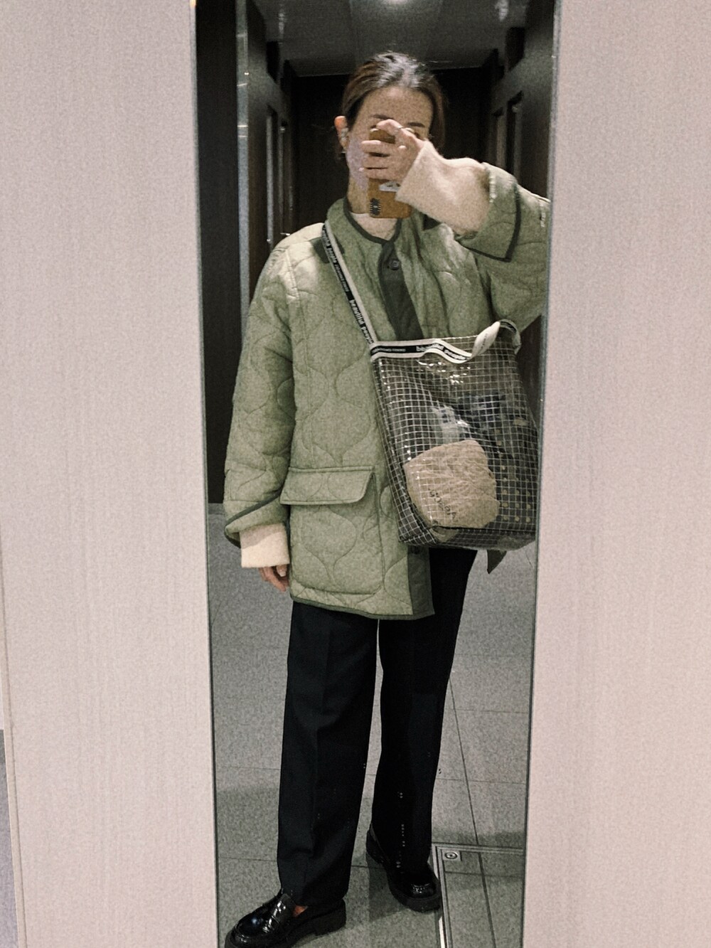 グリーン系のブルゾンを着用したレディースの冬コーディネートの2枚目の写真