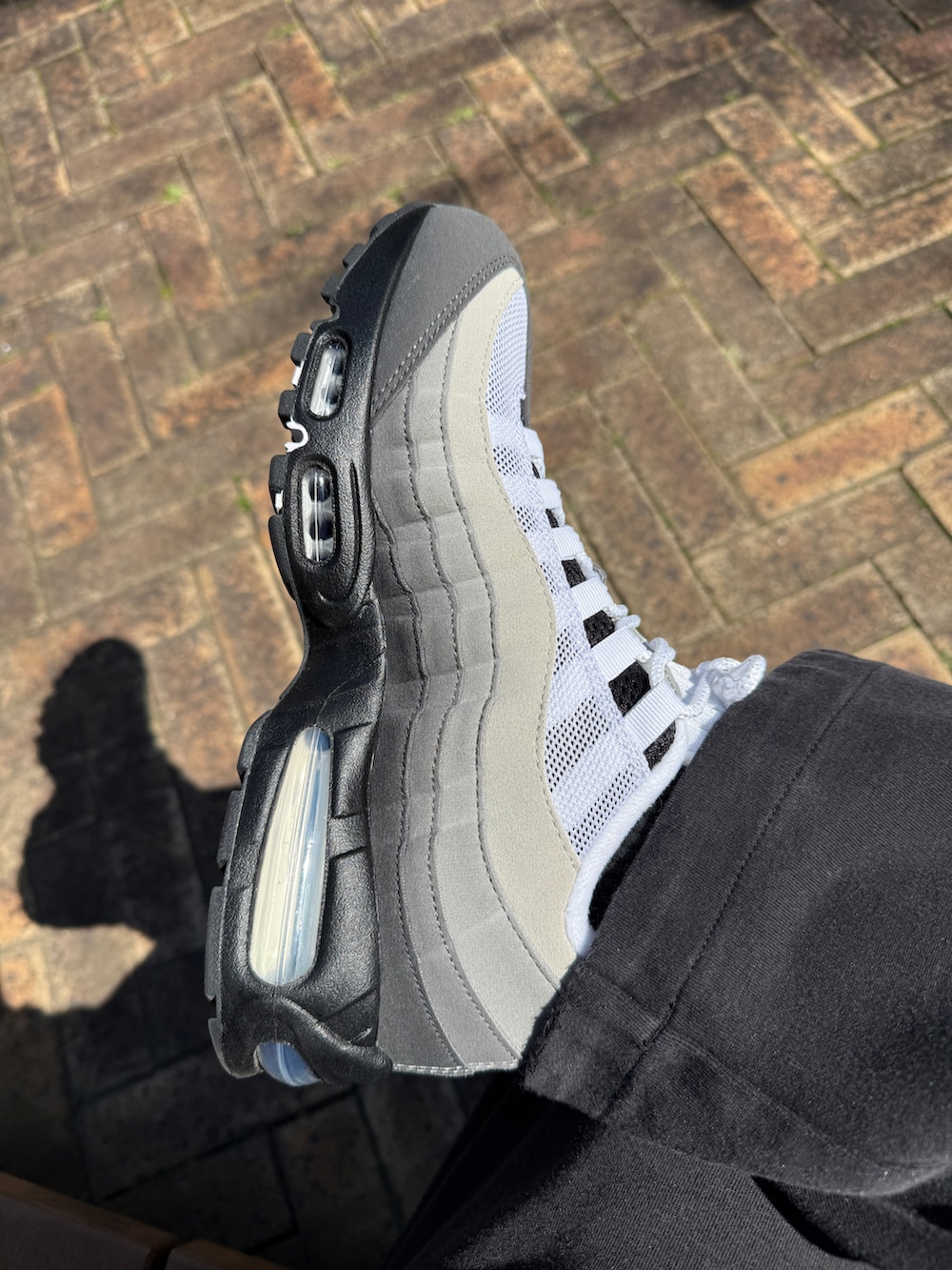 ホワイト系のスニーカーを着用したメンズの春コーディネートの2枚目の写真