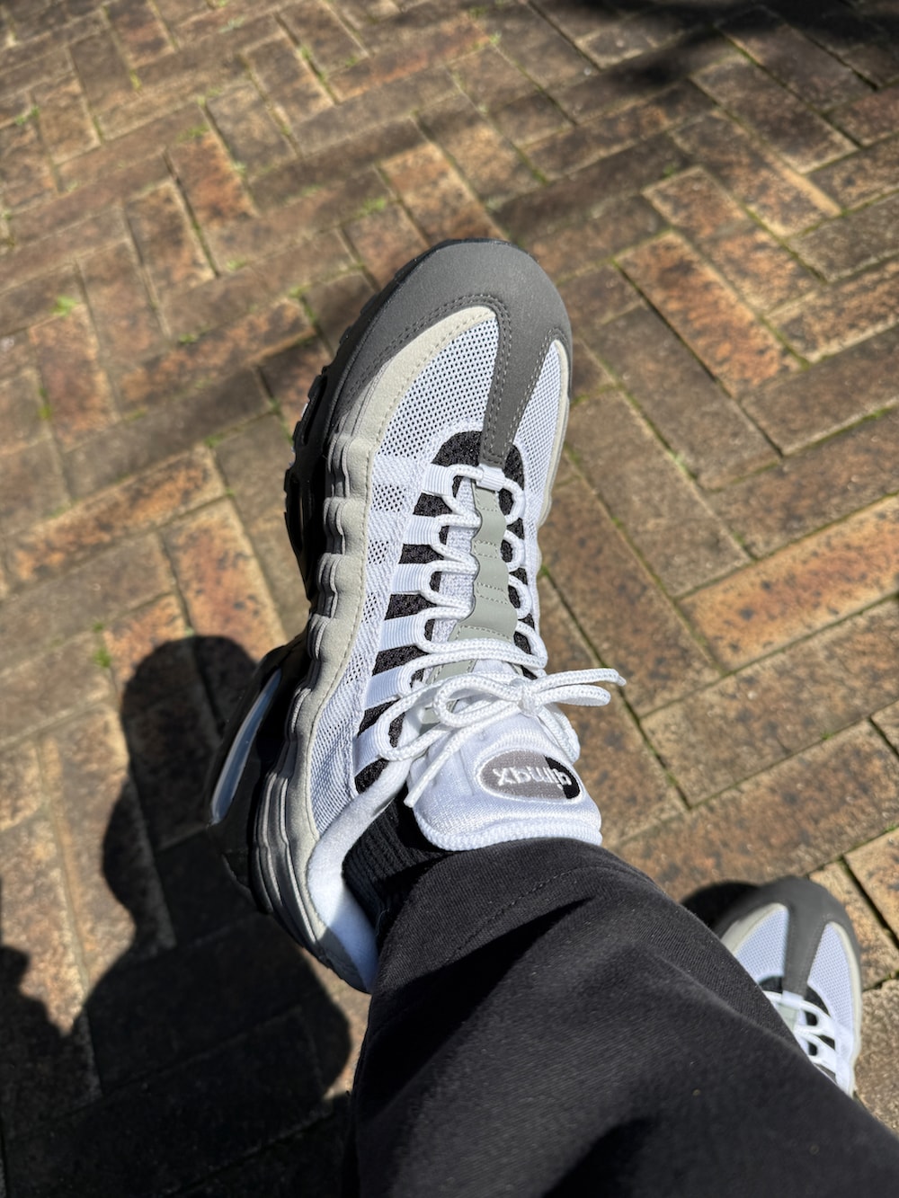 ホワイト系のスニーカーを着用したメンズの春コーディネートの3枚目の写真