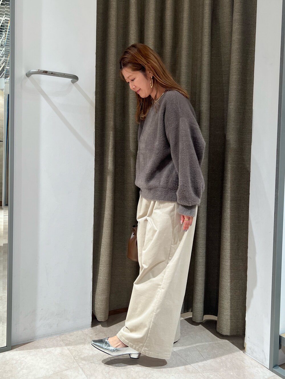 ブラウン系のニット/セーターを着用したレディースの秋コーディネートの2枚目の写真