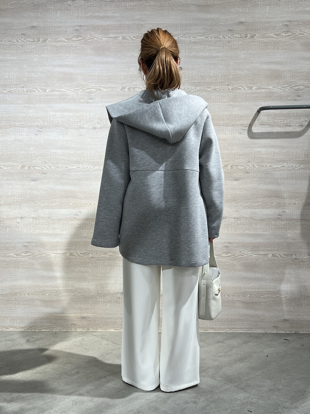 グレー系のその他アウター、イエロー系のニット/セーター、ホワイト系のその他パンツを着用したレディースの冬コーディネートの3枚目の写真