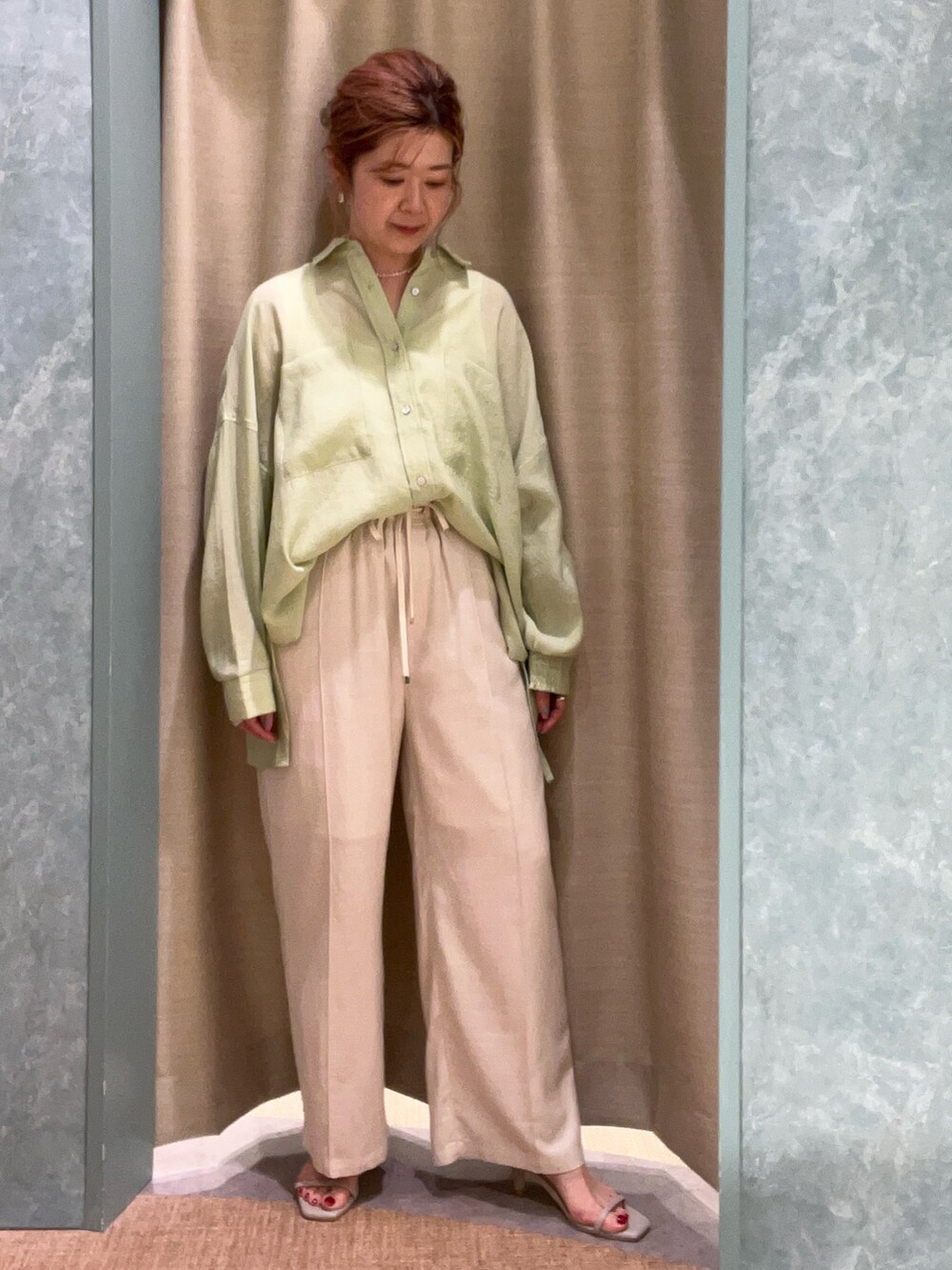 グリーン系のシャツ/ブラウス、ベージュ系のその他パンツを着用したレディースの春コーディネートの3枚目の写真