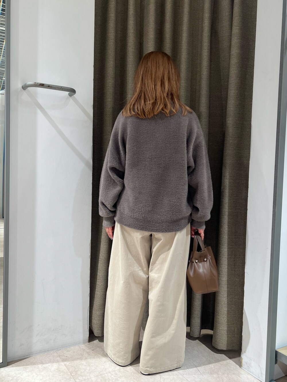 ブラウン系のニット/セーターを着用したレディースの秋コーディネートの3枚目の写真