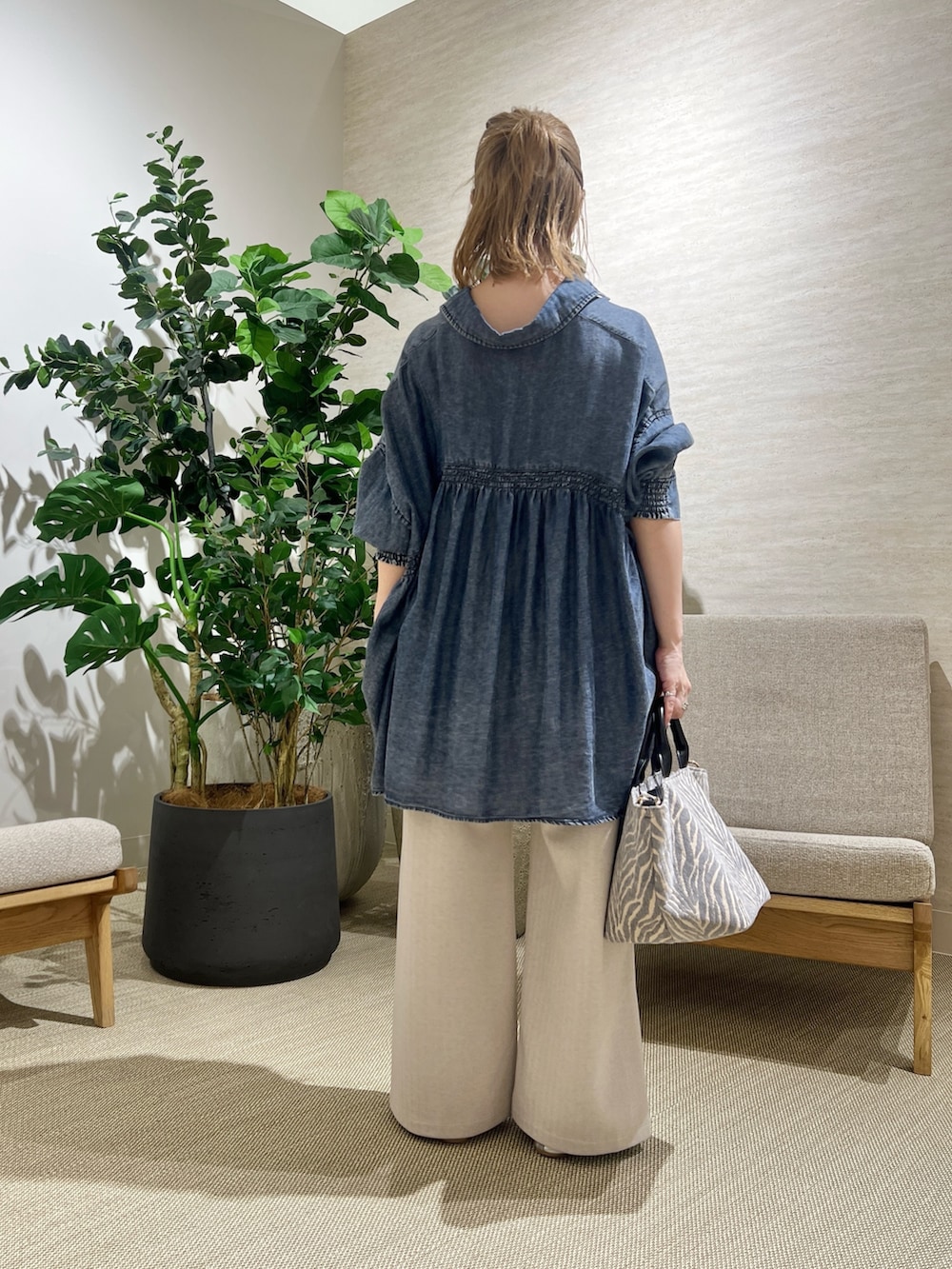 ブルー系のシャツ/ブラウス、ベージュ系のその他パンツ、グレー系のトートバッグを着用したレディースの秋コーディネートの3枚目の写真