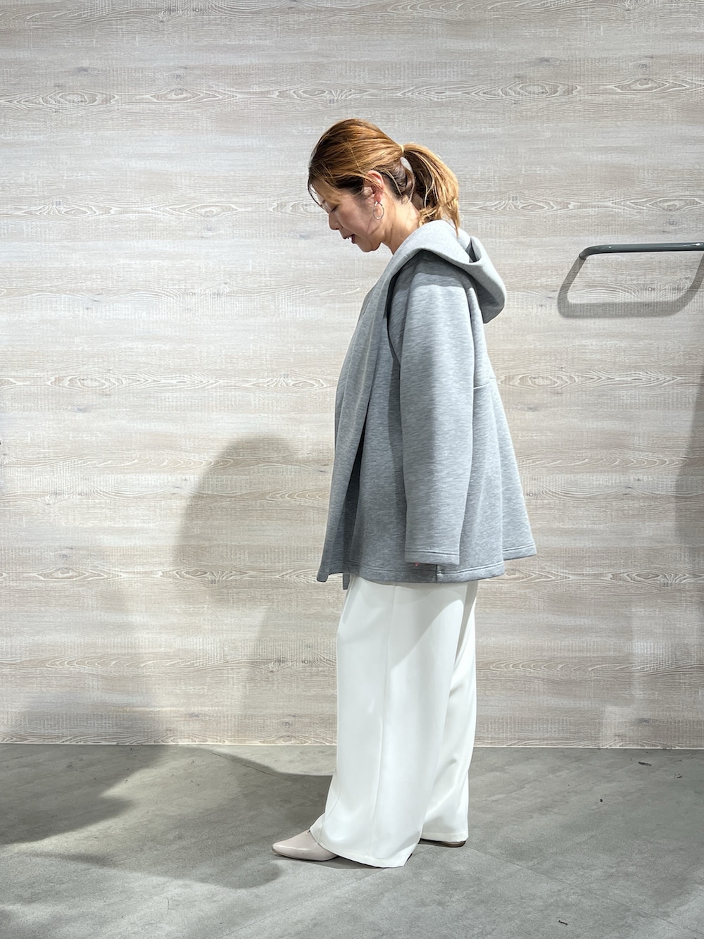 グレー系のその他アウター、イエロー系のニット/セーター、ホワイト系のその他パンツを着用したレディースの冬コーディネートの2枚目の写真