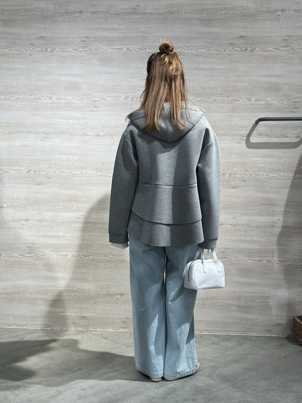 グレー系のパーカー、ブルー系のデニムパンツを着用したレディースの冬コーディネートの3枚目の写真