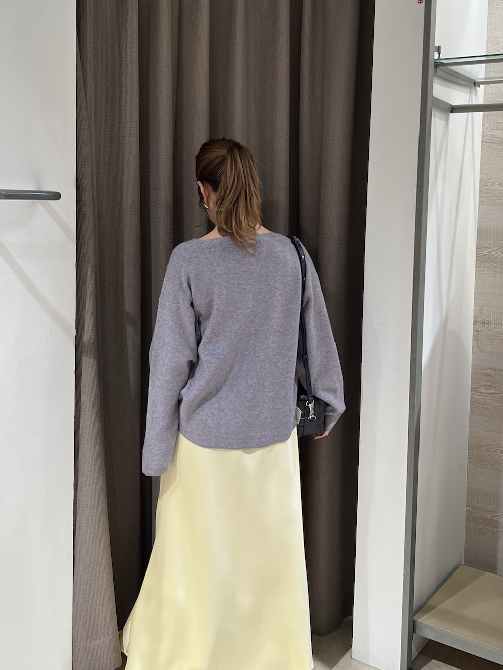 グレー系のニット/セーター、イエロー系のスカートを着用したレディースの春コーディネートの3枚目の写真