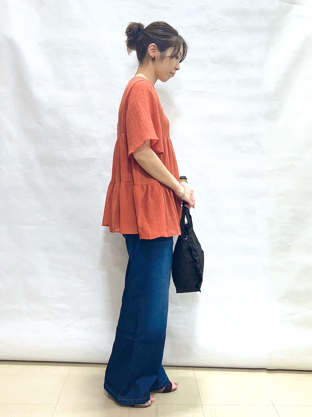 オレンジ系のシャツ/ブラウス、ブルー系のその他パンツ、ブラック系のサンダルを着用したレディースの夏コーディネートの2枚目の写真
