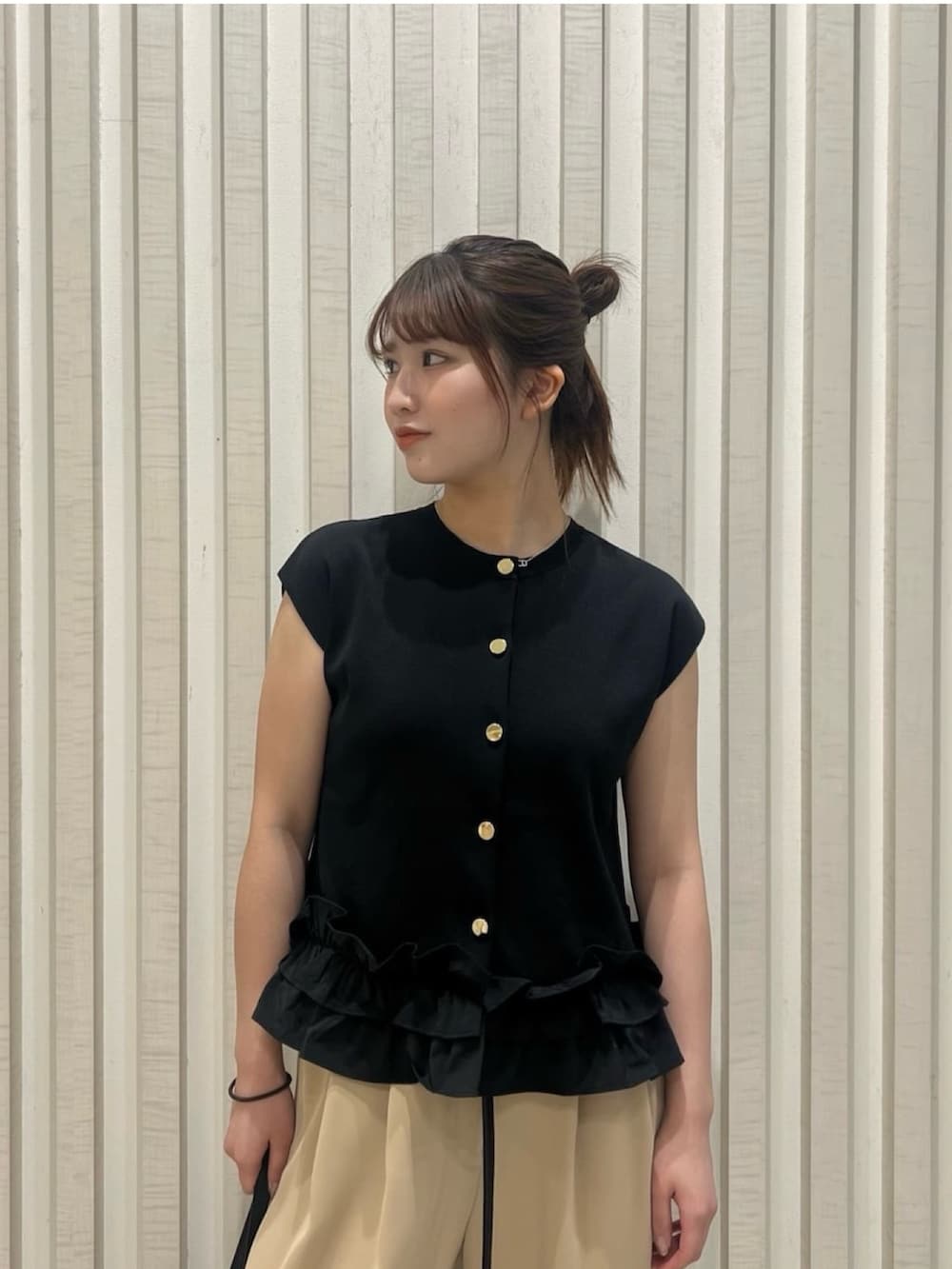 ブラック系のベスト、イエロー系のその他パンツ、ブラウン系のボストンバッグを着用したレディースの夏コーディネートの5枚目の写真