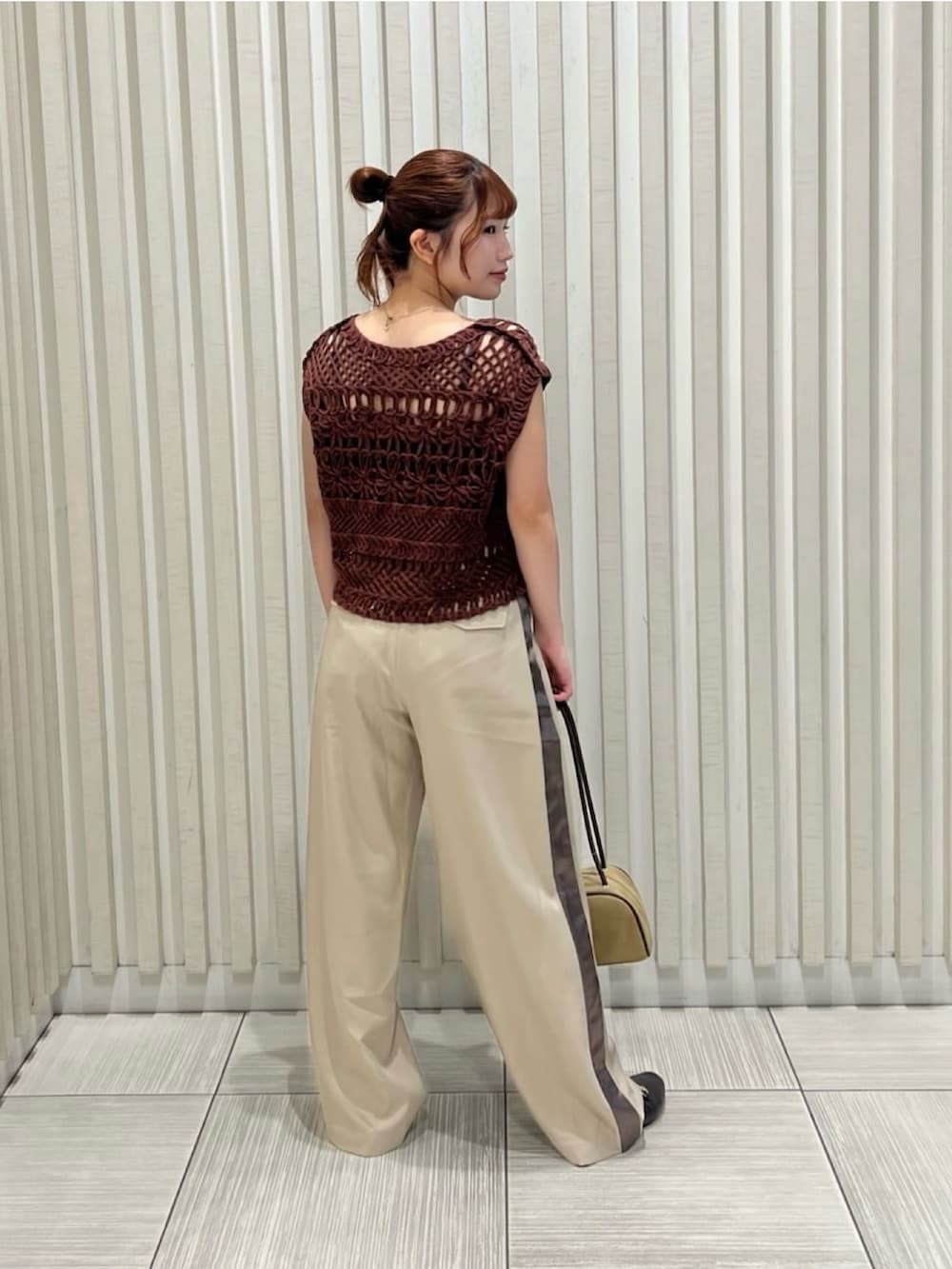 ベージュ系のその他パンツ、ブラウン系のベスト、ベージュ系のボストンバッグを着用したレディースの夏コーディネートの4枚目の写真