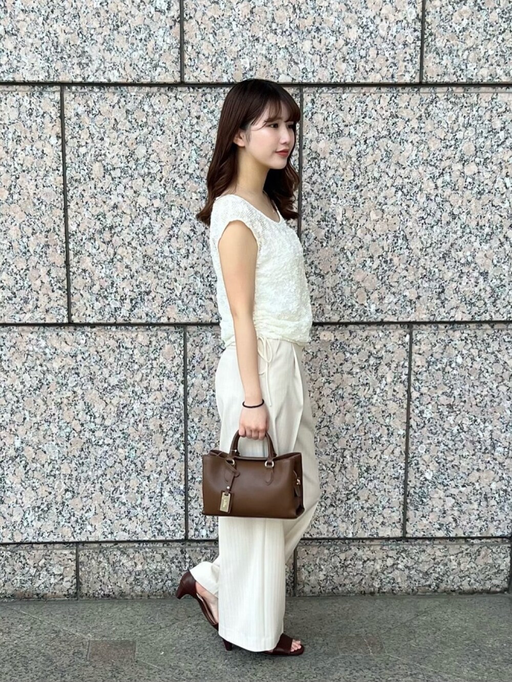 ホワイト系のTシャツ/カットソー、ベージュ系のその他パンツ、ブラウン系のサンダルを着用したレディースの夏コーディネートの3枚目の写真