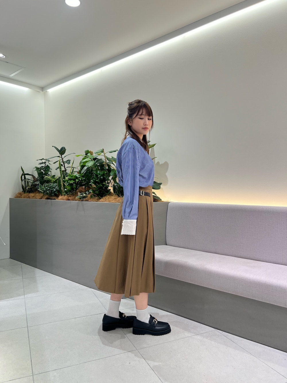 ブラック系のボストンバッグ、ブラック系のローファー、イエロー系のスカートを着用したレディースの夏コーディネートの3枚目の写真