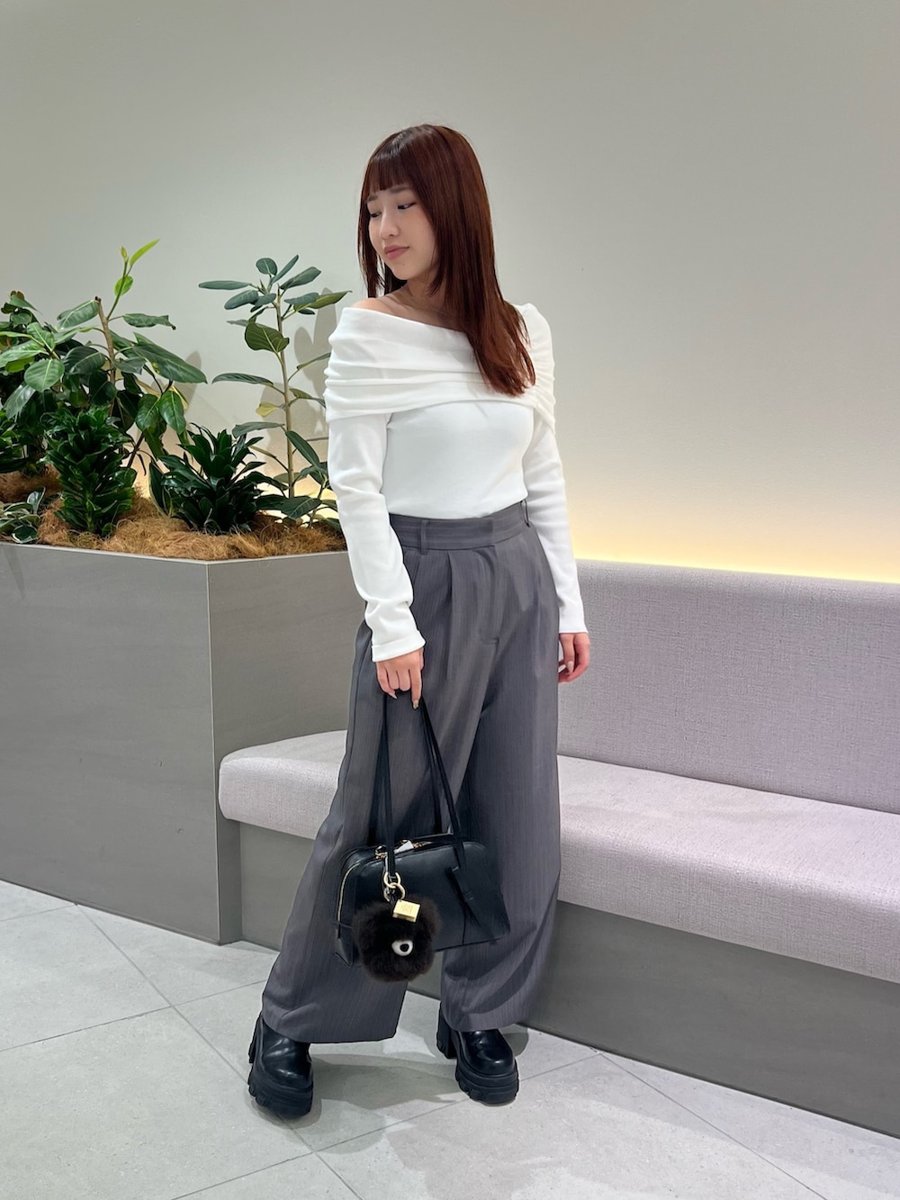 ホワイト系のニット/セーター、ブラック系のボストンバッグ、グレー系のその他パンツを着用したレディースの秋コーディネートの4枚目の写真