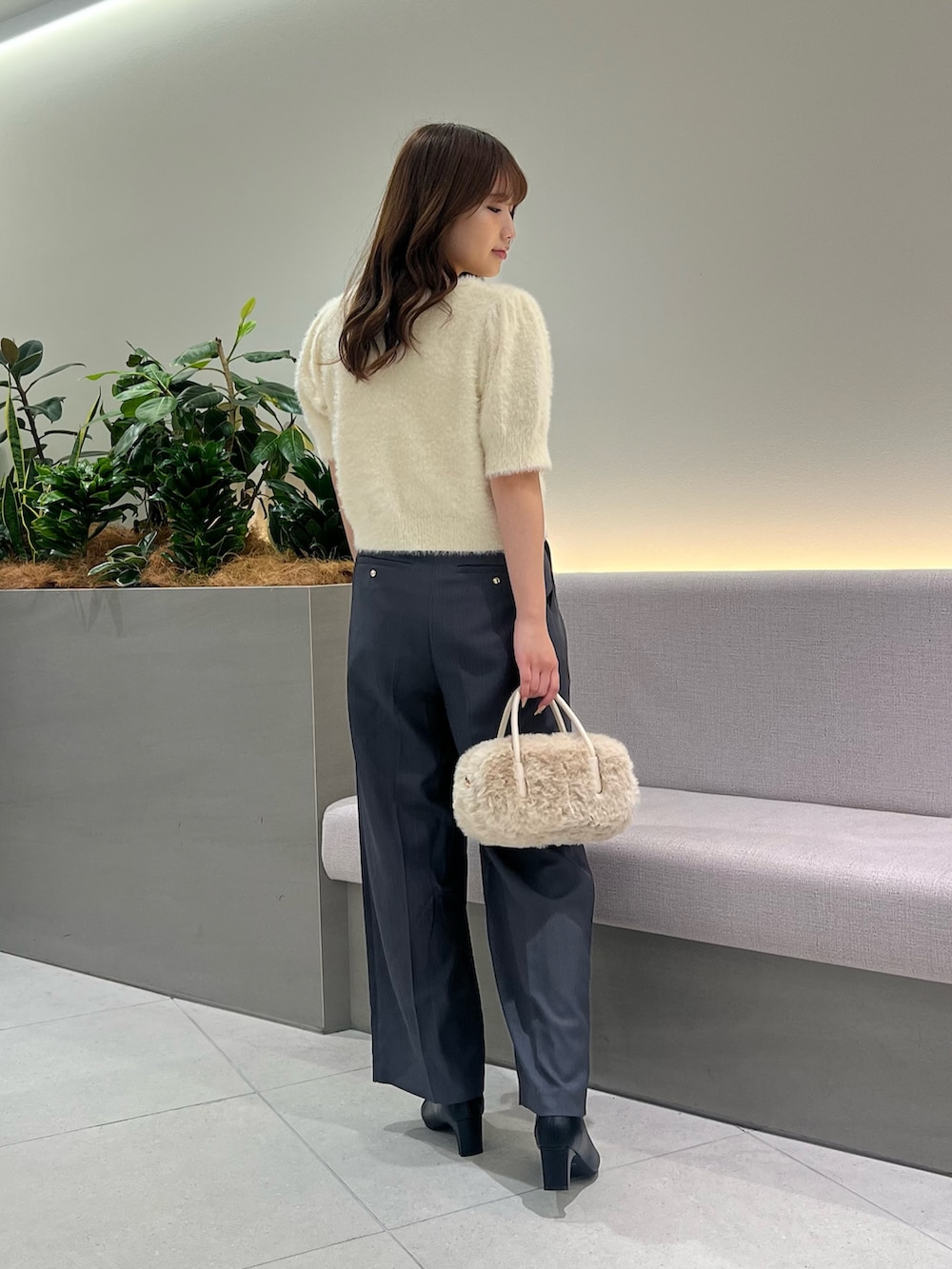 ホワイト系のニット/セーター、グレー系のその他パンツ、ホワイト系のボストンバッグを着用したレディースの秋コーディネートの5枚目の写真