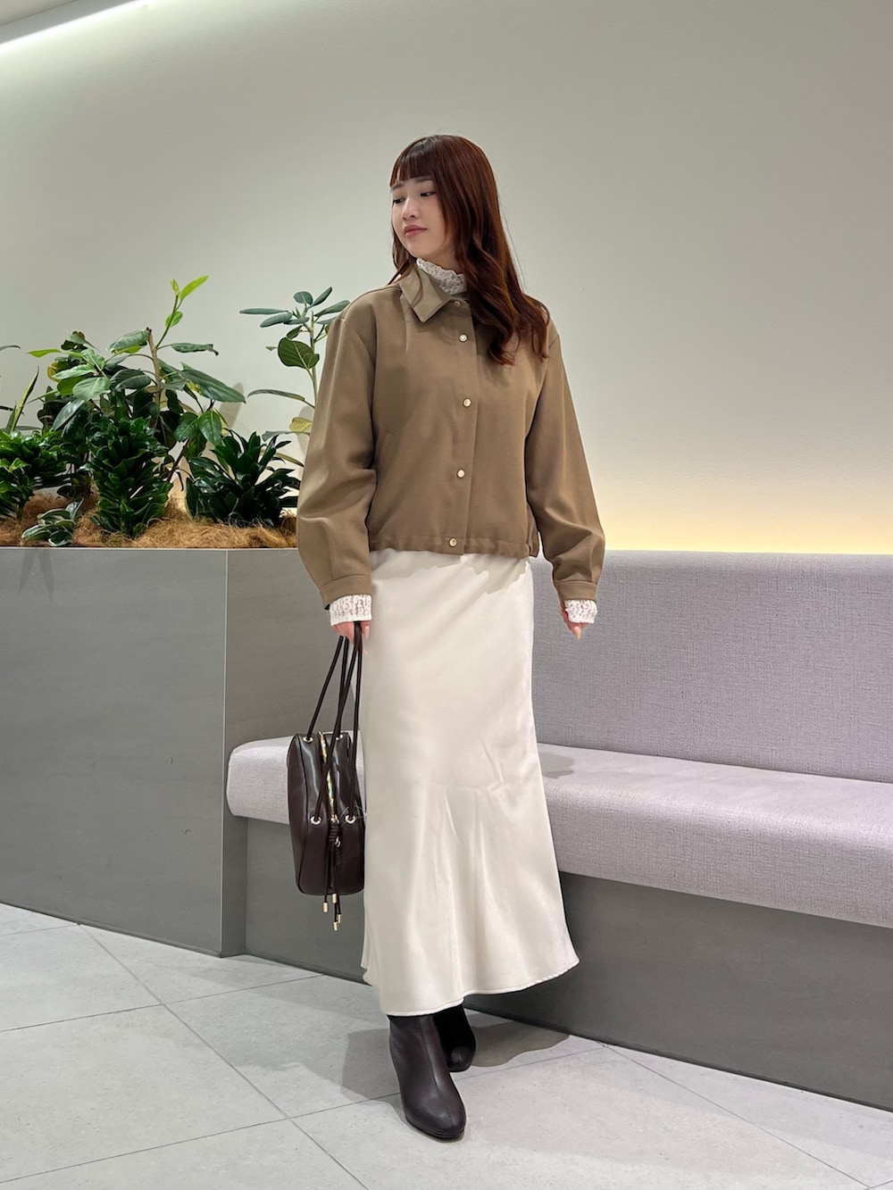 ブラウン系のブルゾン、ホワイト系のTシャツ/カットソー、ブラウン系のボストンバッグを着用したレディースの秋コーディネートの3枚目の写真
