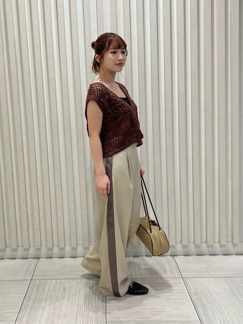 ベージュ系のその他パンツ、ブラウン系のベスト、ベージュ系のボストンバッグを着用したレディースの夏コーディネートの3枚目の写真
