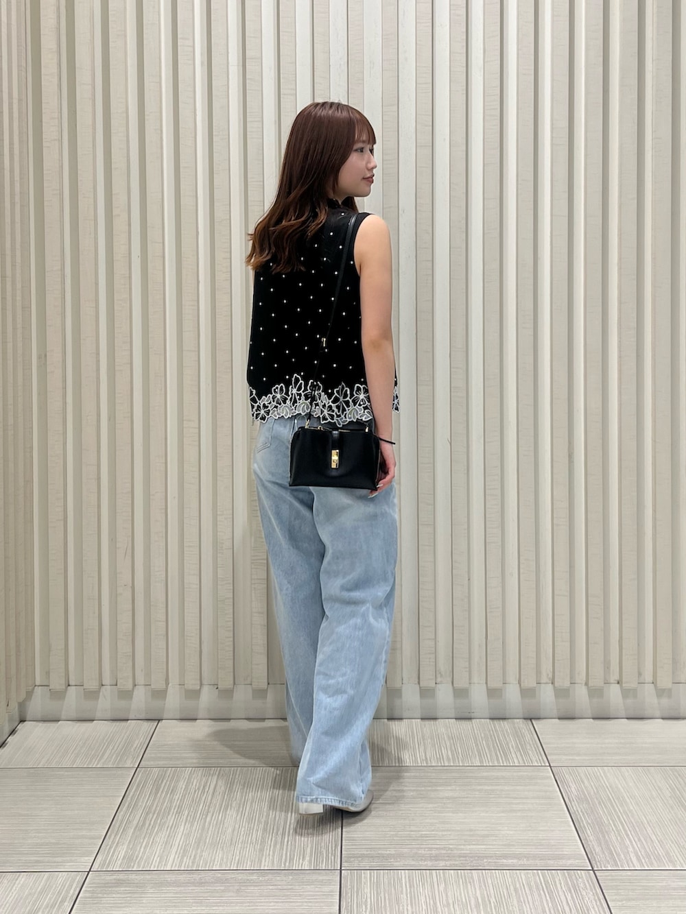 ブラック系のシャツ/ブラウス、ブラック系のショルダーバッグ、ブルー系のデニムパンツを着用したレディースの夏コーディネートの4枚目の写真