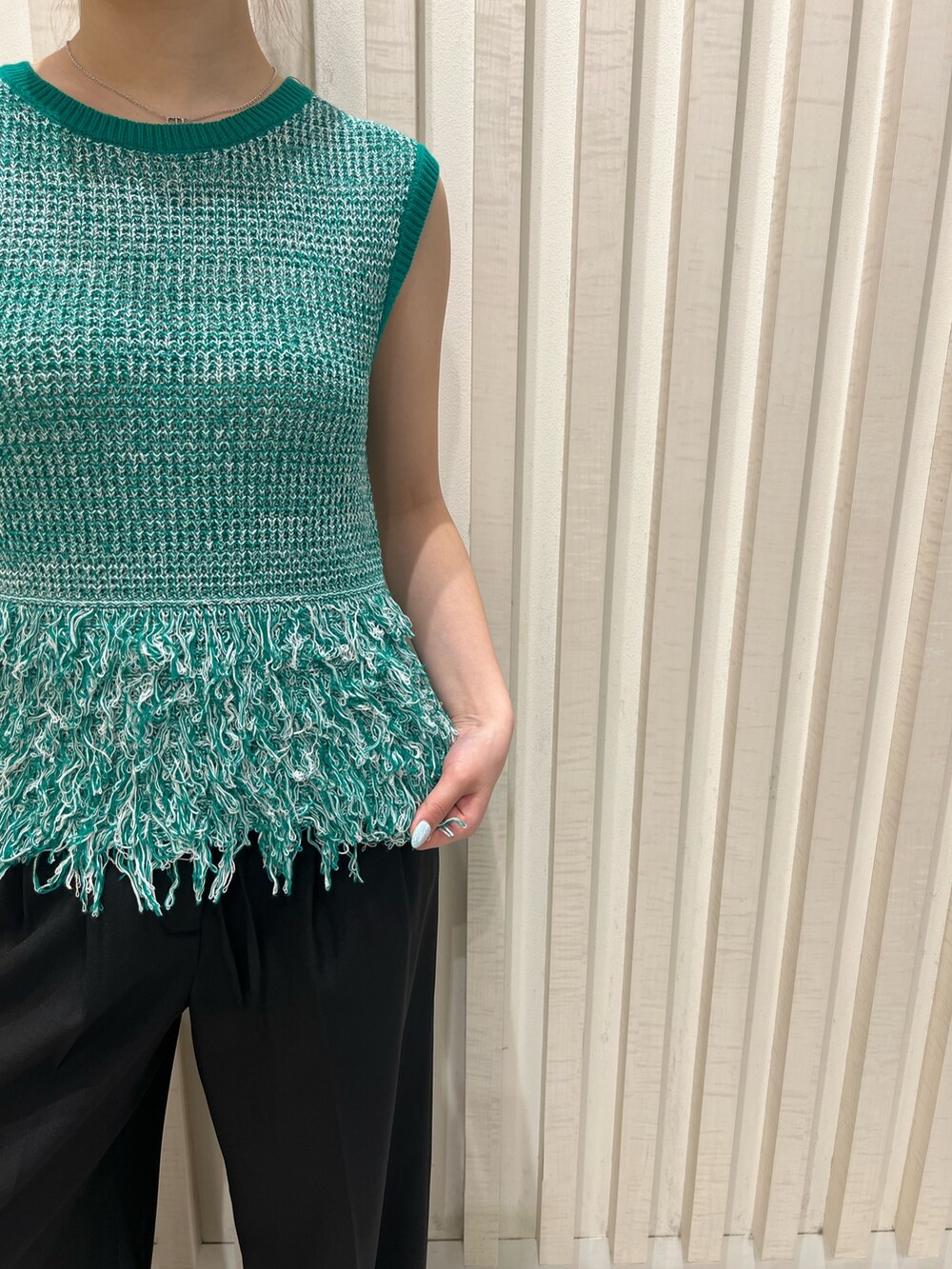 グリーン系のニット/セーター、ブラック系のその他パンツ、ブラウン系のボストンバッグを着用したレディースの夏コーディネートの6枚目の写真