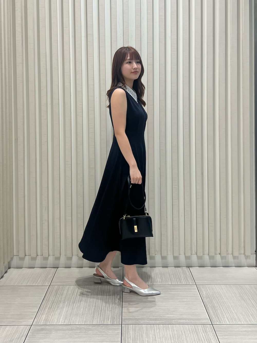 ブルー系のワンピース、ブラック系のショルダーバッグを着用したレディースの夏コーディネートの3枚目の写真