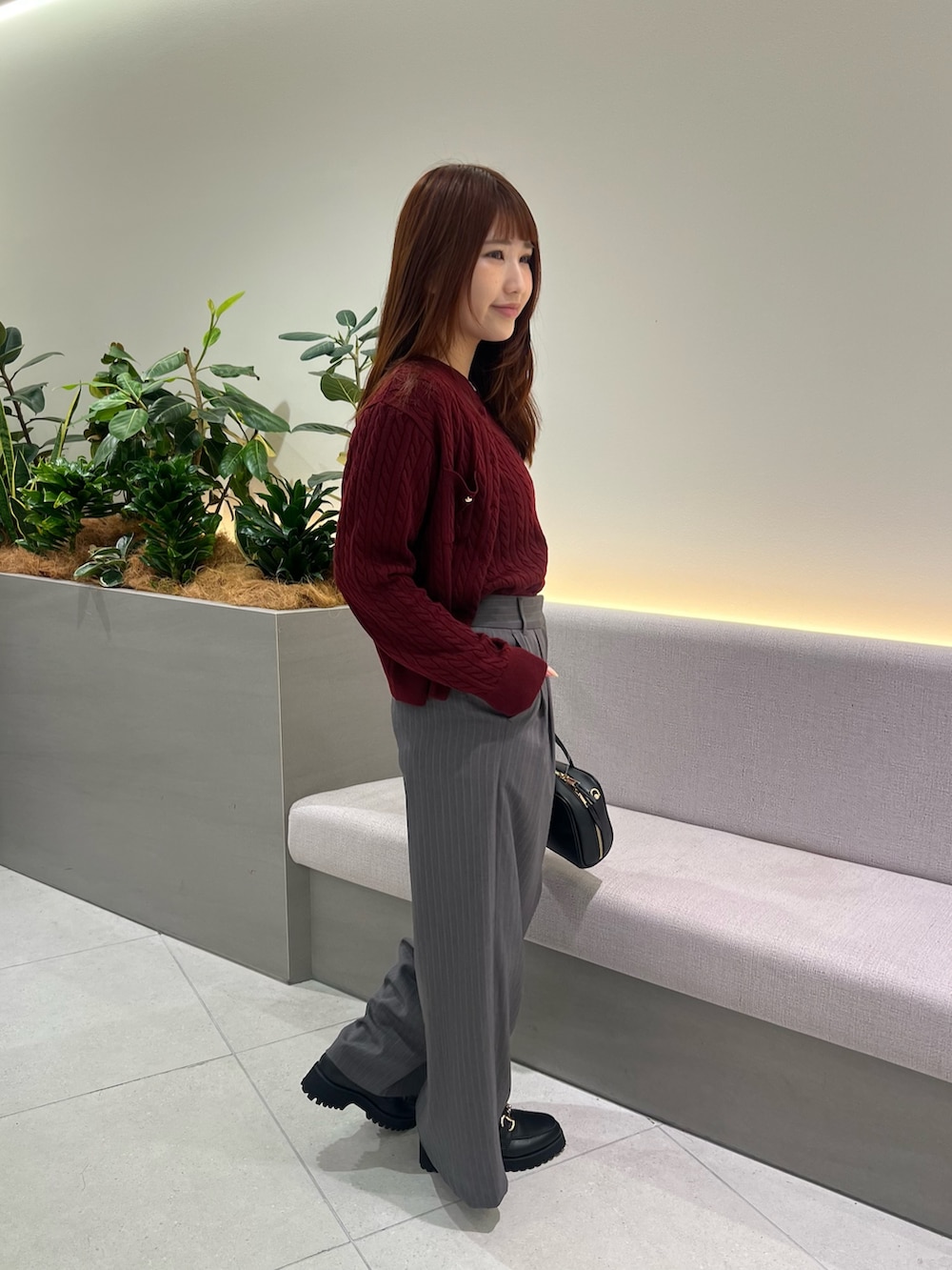 レッド系のアンサンブル、ブラック系のローファー、グレー系のその他パンツを着用したレディースの秋コーディネートの3枚目の写真