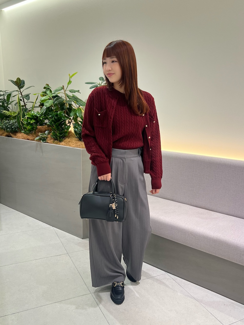 レッド系のアンサンブル、ブラック系のローファー、グレー系のその他パンツを着用したレディースの秋コーディネートの2枚目の写真
