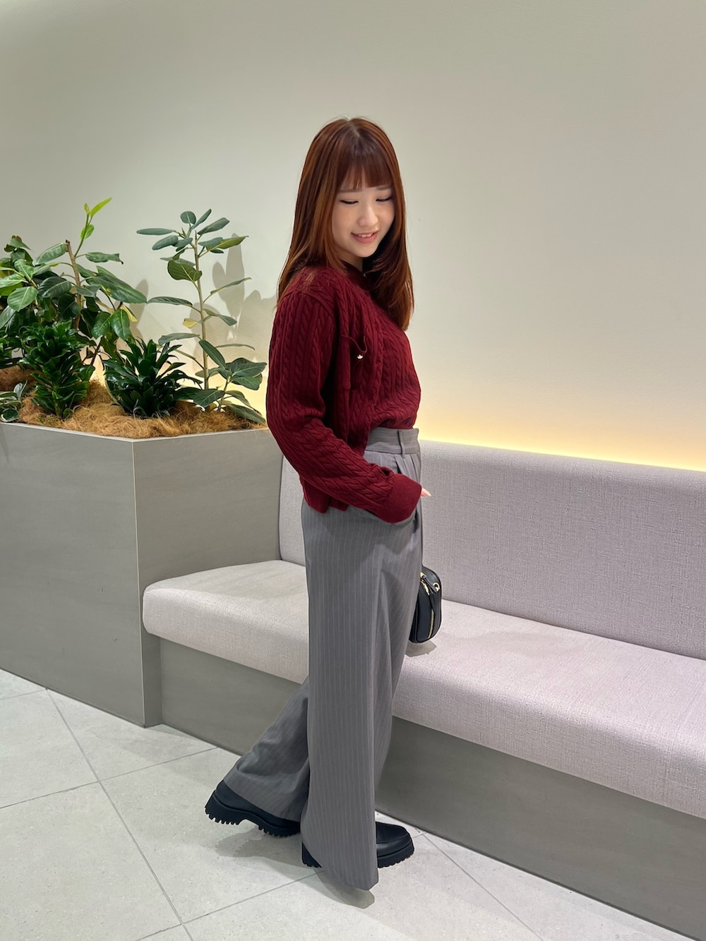 レッド系のアンサンブル、ブラック系のローファー、グレー系のその他パンツを着用したレディースの秋コーディネートの6枚目の写真