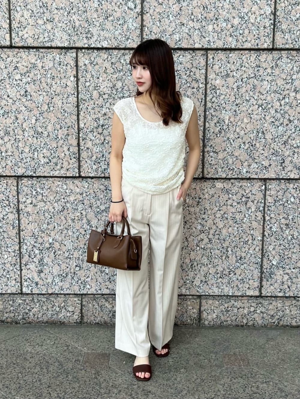 ホワイト系のTシャツ/カットソー、ベージュ系のその他パンツ、ブラウン系のサンダルを着用したレディースの夏コーディネートの2枚目の写真