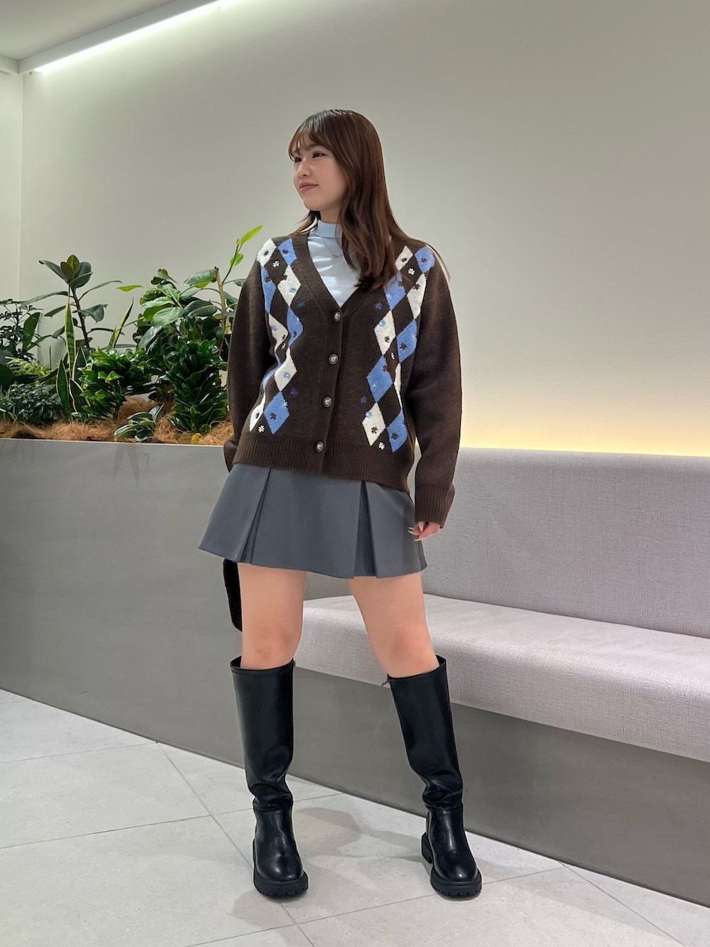 ブラウン系のカーディガン/ボレロ、ブルー系のTシャツ/カットソー、グレー系のスカートを着用したレディースの秋コーディネートの3枚目の写真