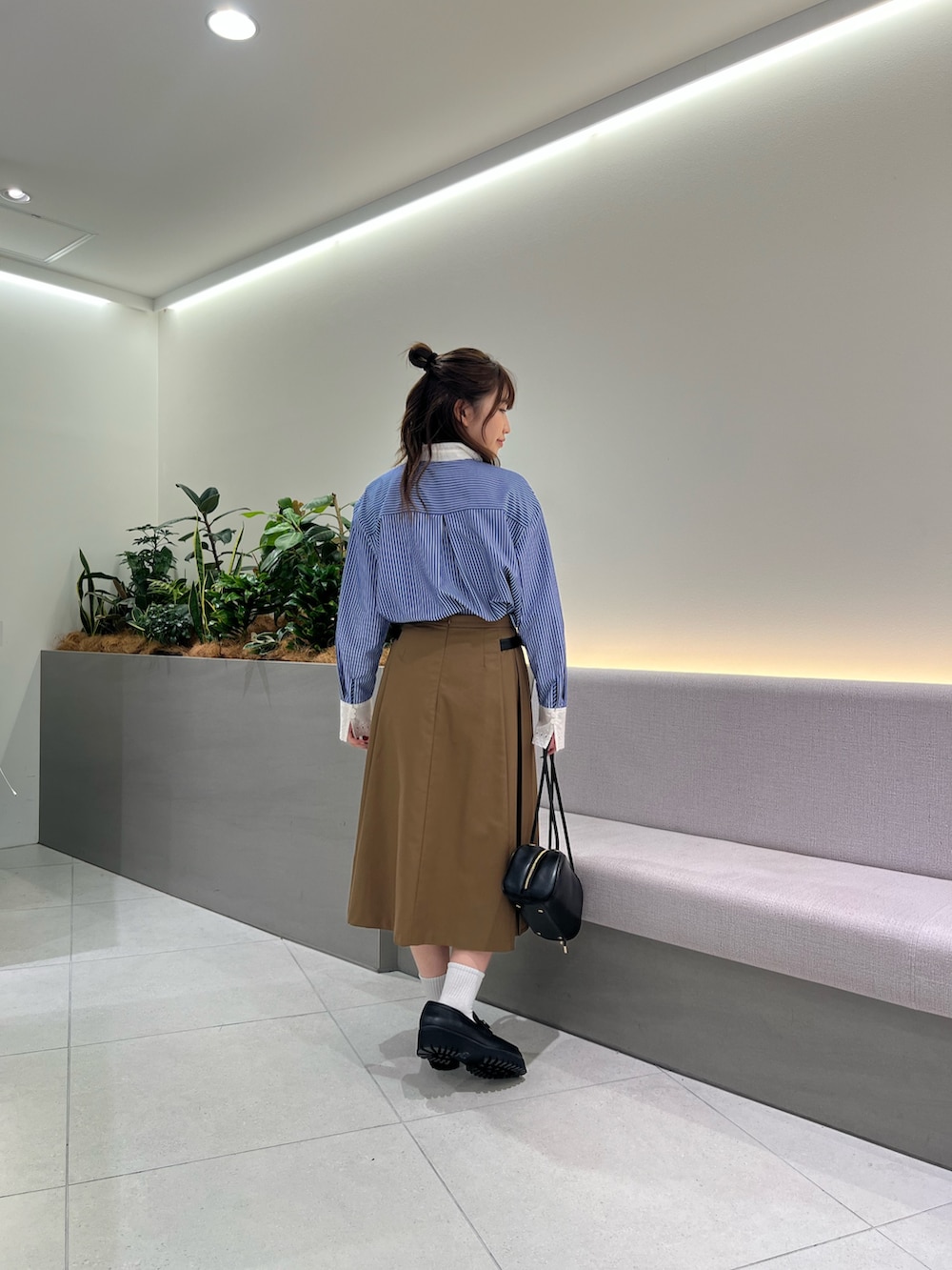 ブラック系のボストンバッグ、ブラック系のローファー、イエロー系のスカートを着用したレディースの夏コーディネートの5枚目の写真