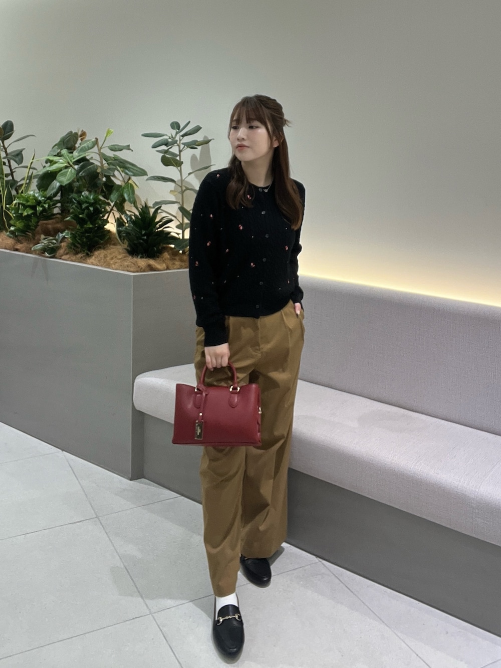 ブラック系のカーディガン/ボレロ、イエロー系のその他パンツ、レッド系のショルダーバッグを着用したレディースの秋コーディネートの2枚目の写真