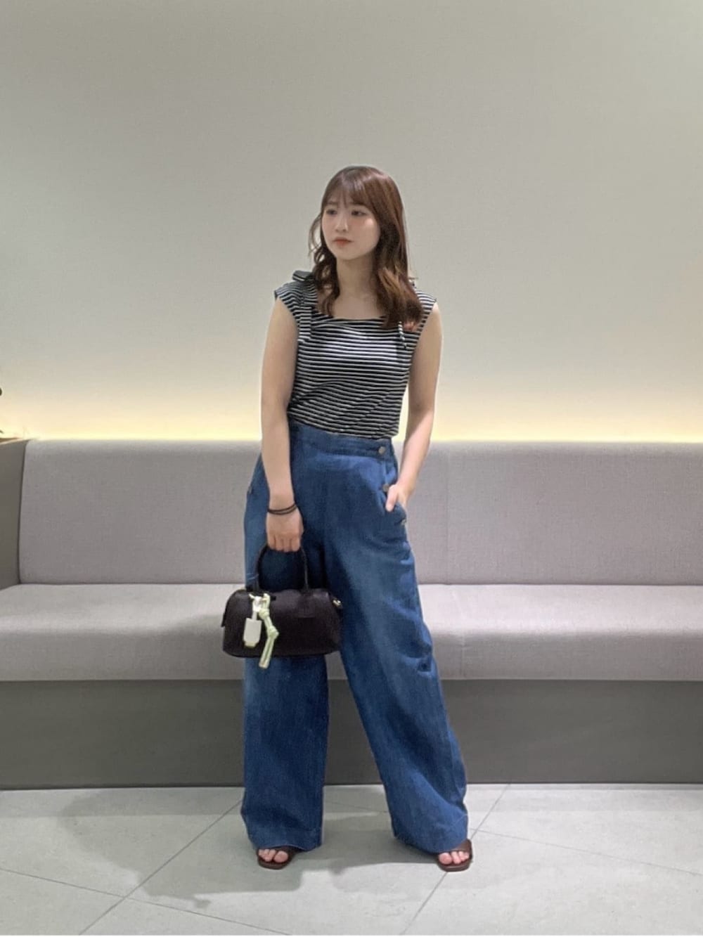 ブルー系のTシャツ/カットソー、ブルー系のデニムパンツ、ブラウン系のサンダルを着用したレディースの夏コーディネートの2枚目の写真