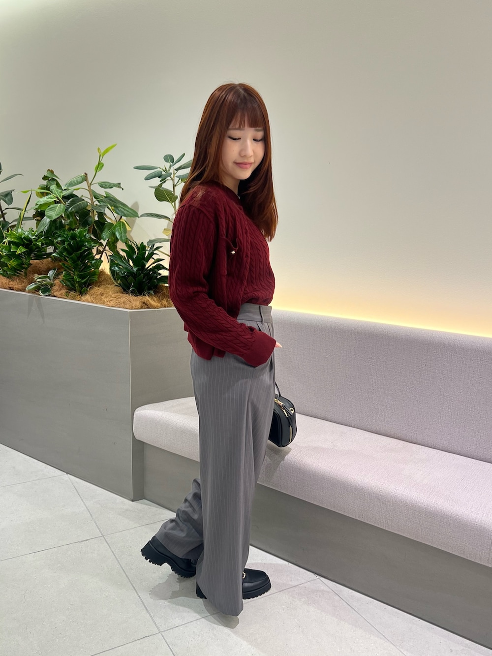 レッド系のアンサンブル、ブラック系のローファー、グレー系のその他パンツを着用したレディースの秋コーディネートの4枚目の写真