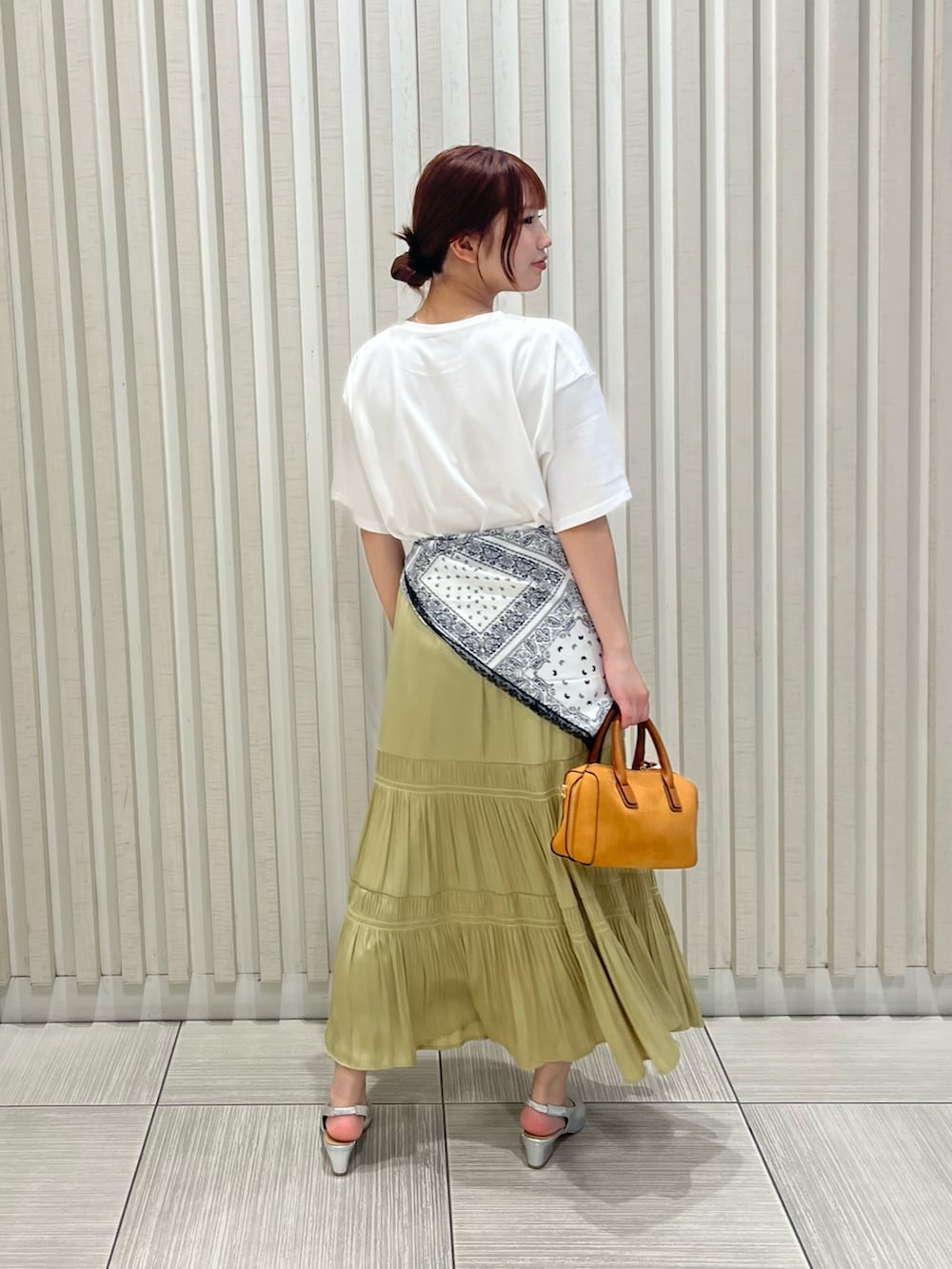 ホワイト系のTシャツ/カットソー、イエロー系のスカート、オレンジ系のボストンバッグを着用したレディースの夏コーディネートの5枚目の写真