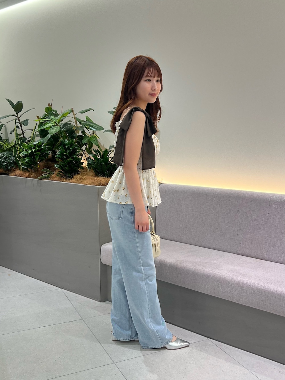 ベージュ系のシャツ/ブラウス、ブルー系のデニムパンツ、ブラウン系のボストンバッグを着用したレディースの夏コーディネートの3枚目の写真