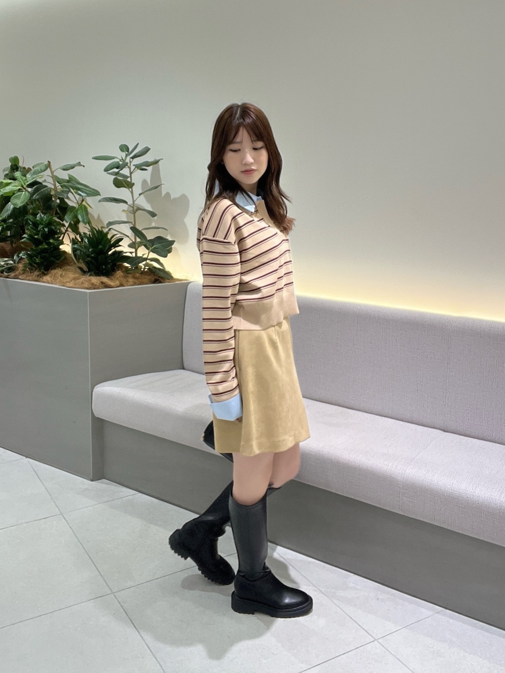 ベージュ系のニット/セーター、ベージュ系のスカート、ブラック系のブーツを着用したレディースの夏コーディネートの3枚目の写真