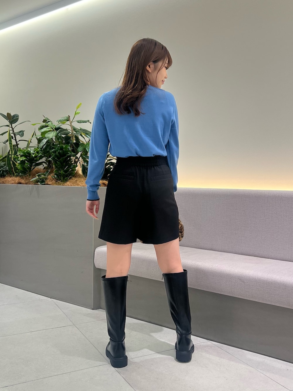 ブルー系のカーディガン/ボレロ、ブラック系のその他パンツ、ブラウン系のボストンバッグを着用したレディースの秋コーディネートの6枚目の写真