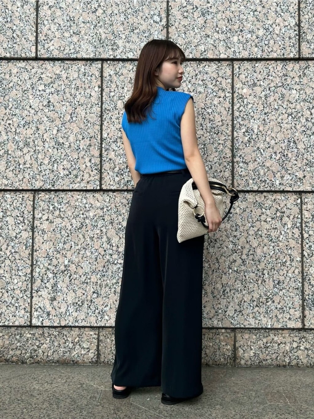 ブルー系のニット/セーター、ホワイト系のショルダーバッグ、ブラック系のその他パンツを着用したレディースの夏コーディネートの5枚目の写真