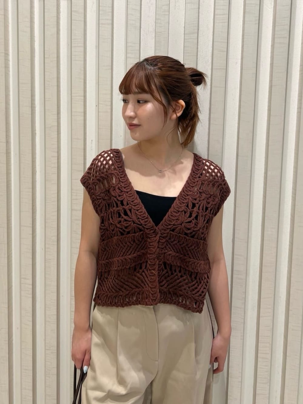 ベージュ系のその他パンツ、ブラウン系のベスト、ベージュ系のボストンバッグを着用したレディースの夏コーディネートの5枚目の写真