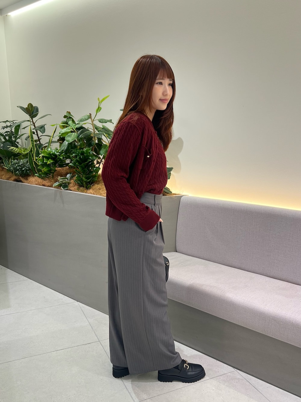 レッド系のアンサンブル、ブラック系のローファー、グレー系のその他パンツを着用したレディースの秋コーディネートの5枚目の写真