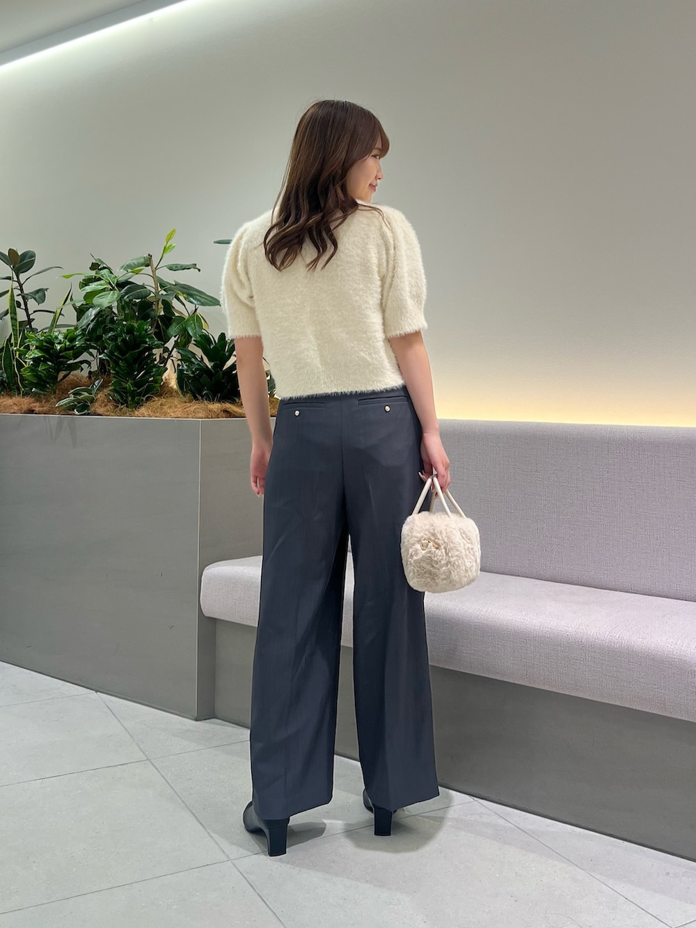 ホワイト系のニット/セーター、グレー系のその他パンツ、ホワイト系のボストンバッグを着用したレディースの秋コーディネートの6枚目の写真